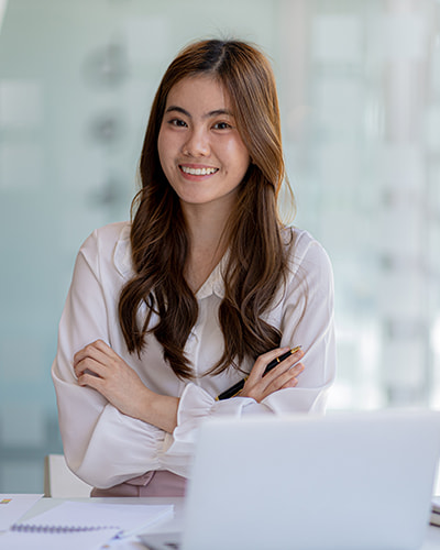 a female smiling with her hands crossed