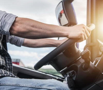 a person holding a steering wheel in a vehicle