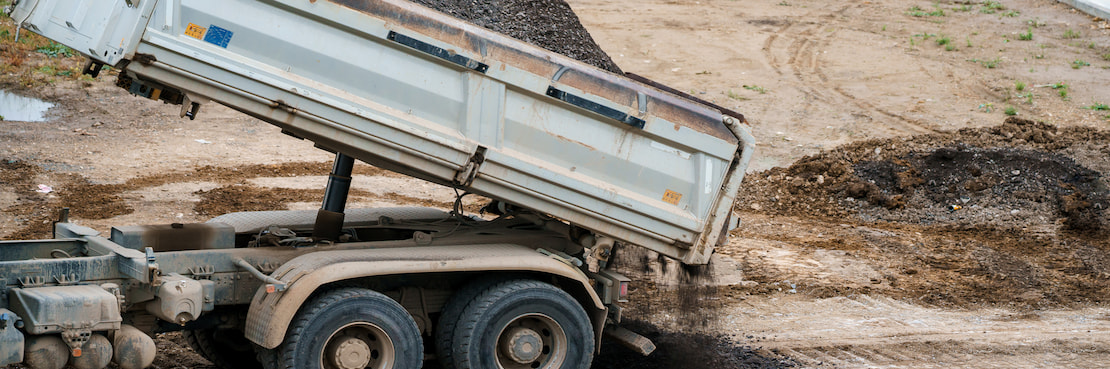 white dump truck unloading gravel